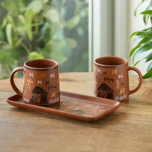 ExclusiveLane 'Warli Village Tales' Ceramic Tea & Coffee Mugs With Tray (Set of 2, 300 ML, Microwave Safe, Handcrafted) ExclusiveLane 'Warli Village Tales' Ceramic Tea & Coffee Mugs With Tray (Set of 2, 300 ML, Microwave Safe, Handcrafted)